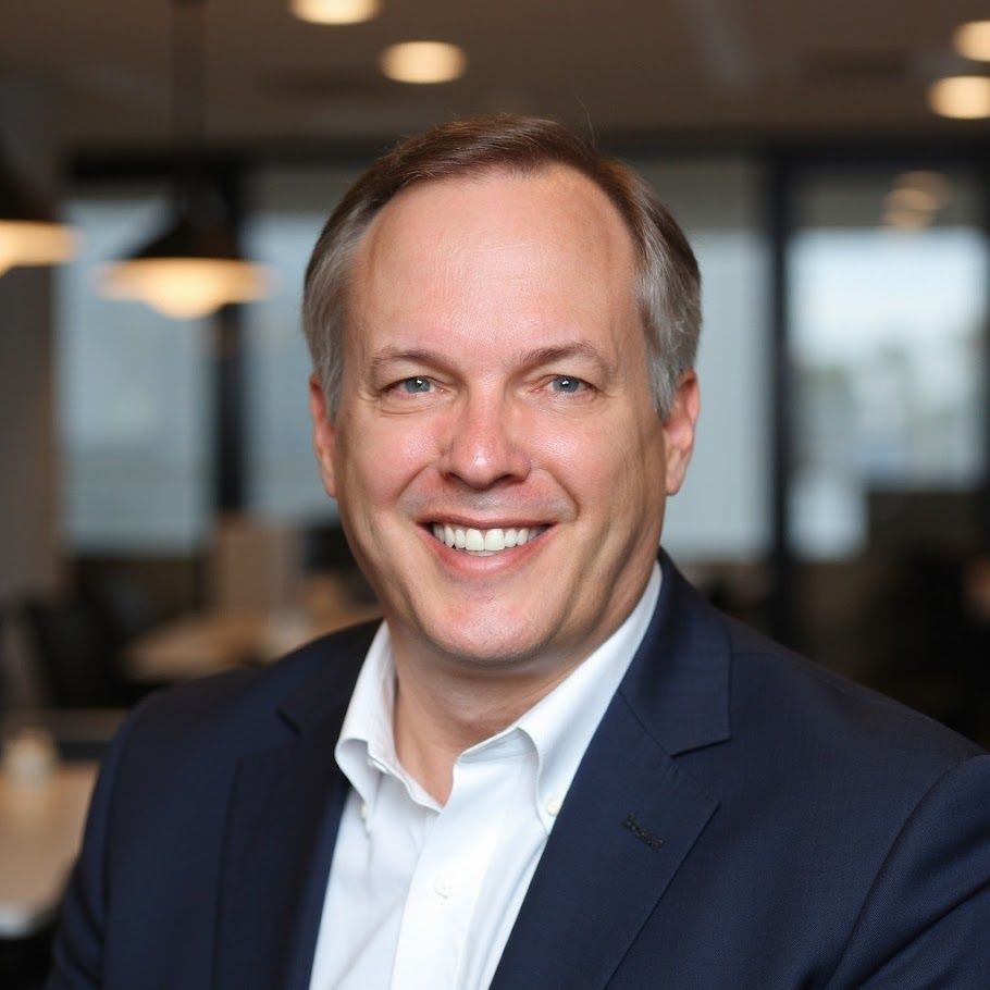 A man in a suit and tie is smiling for the camera