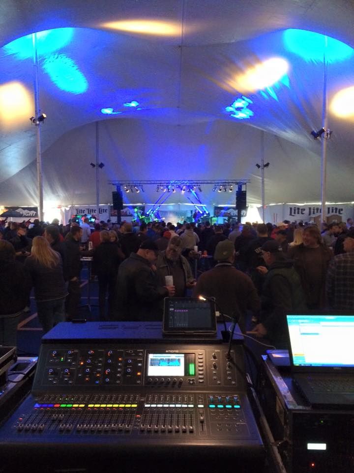 A large crowd of people are gathered in a large tent.