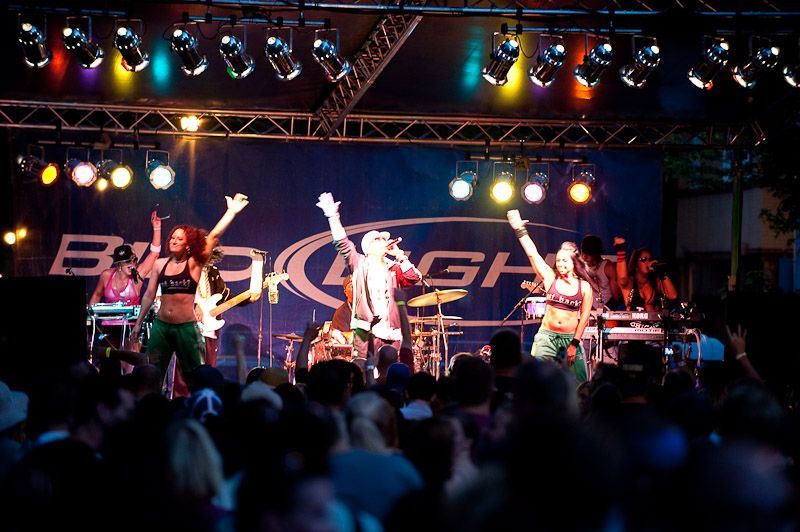 A group of people are dancing on a stage in front of a sign that says smash