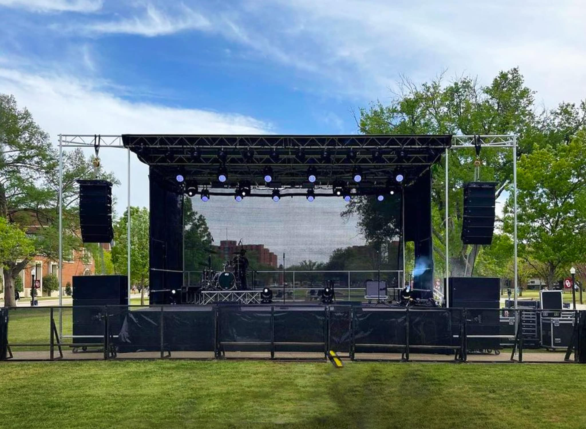 A large stage is sitting in the middle of a grassy field.