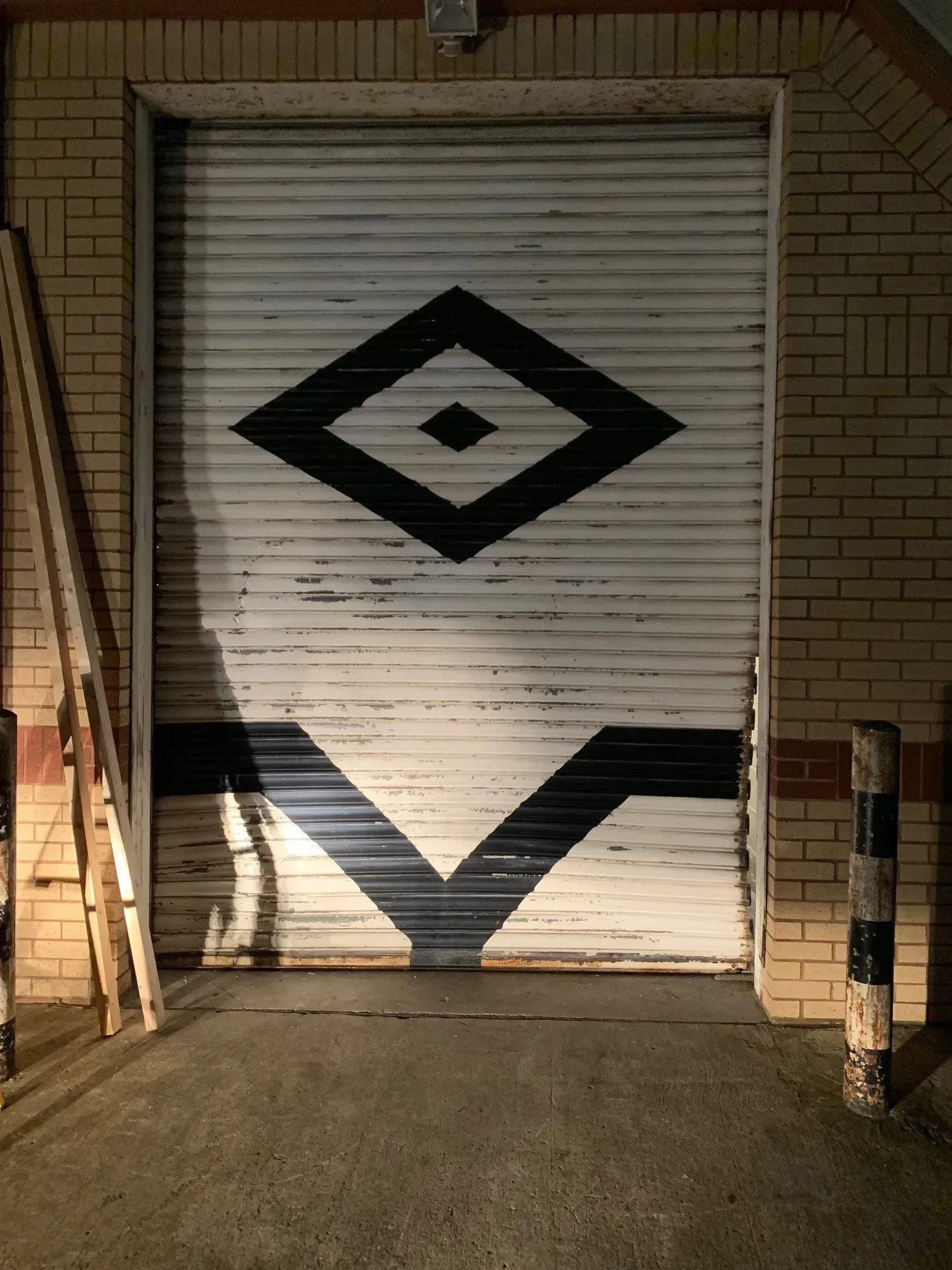 White garage door with a black Minion eye design and V-shaped mouth.