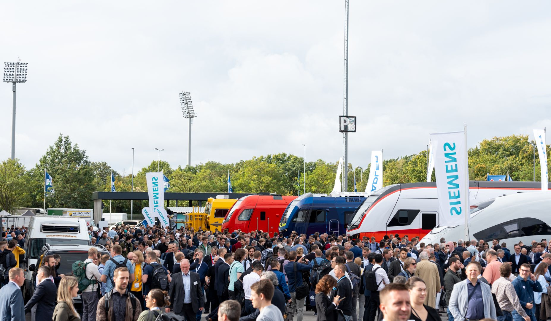 Besucher der Innotrans 2024 vor diversen Zügen auf dem Messegelände in Berlin