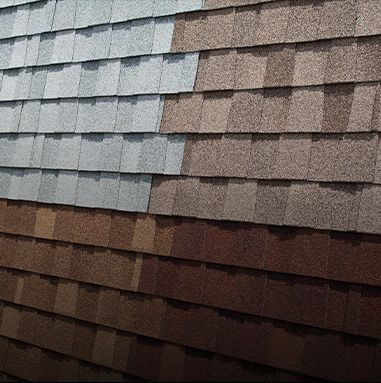 Close-up of a roof with various shades of gray and brown shingles.