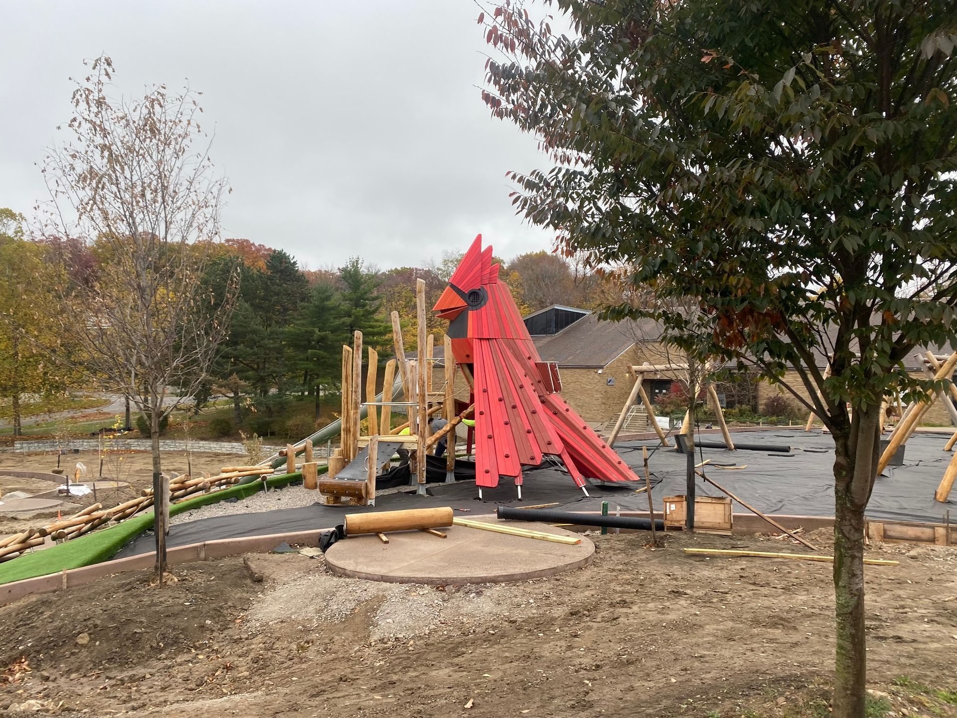 Playground under construction with a large red climbing structure.