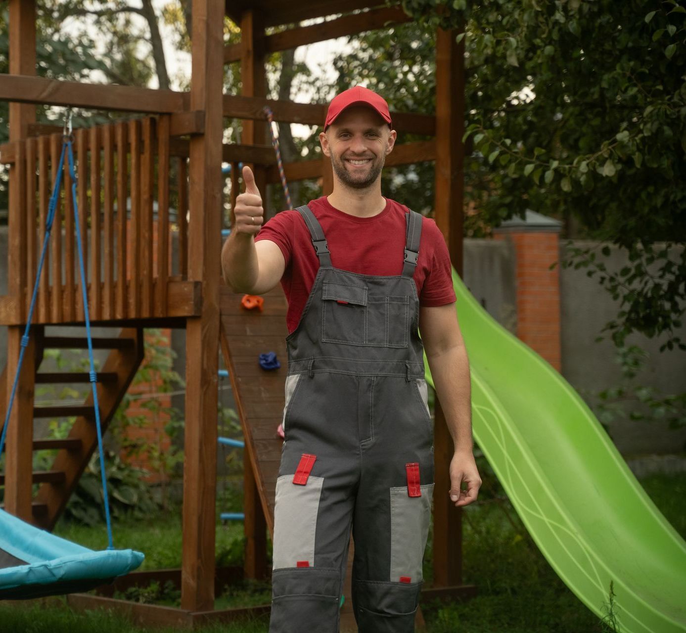 A worker with a thumbs-up in a children’s playground.