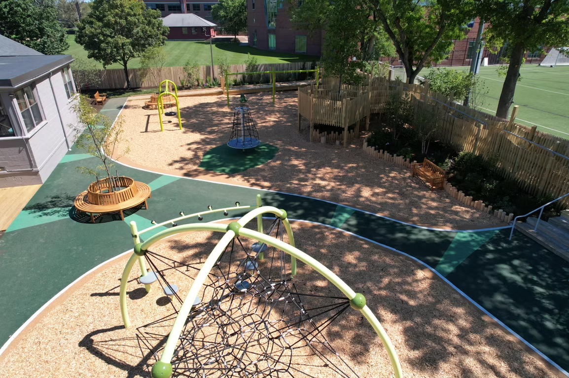 Playground with a climbing dome, wood chips, and various play structures.