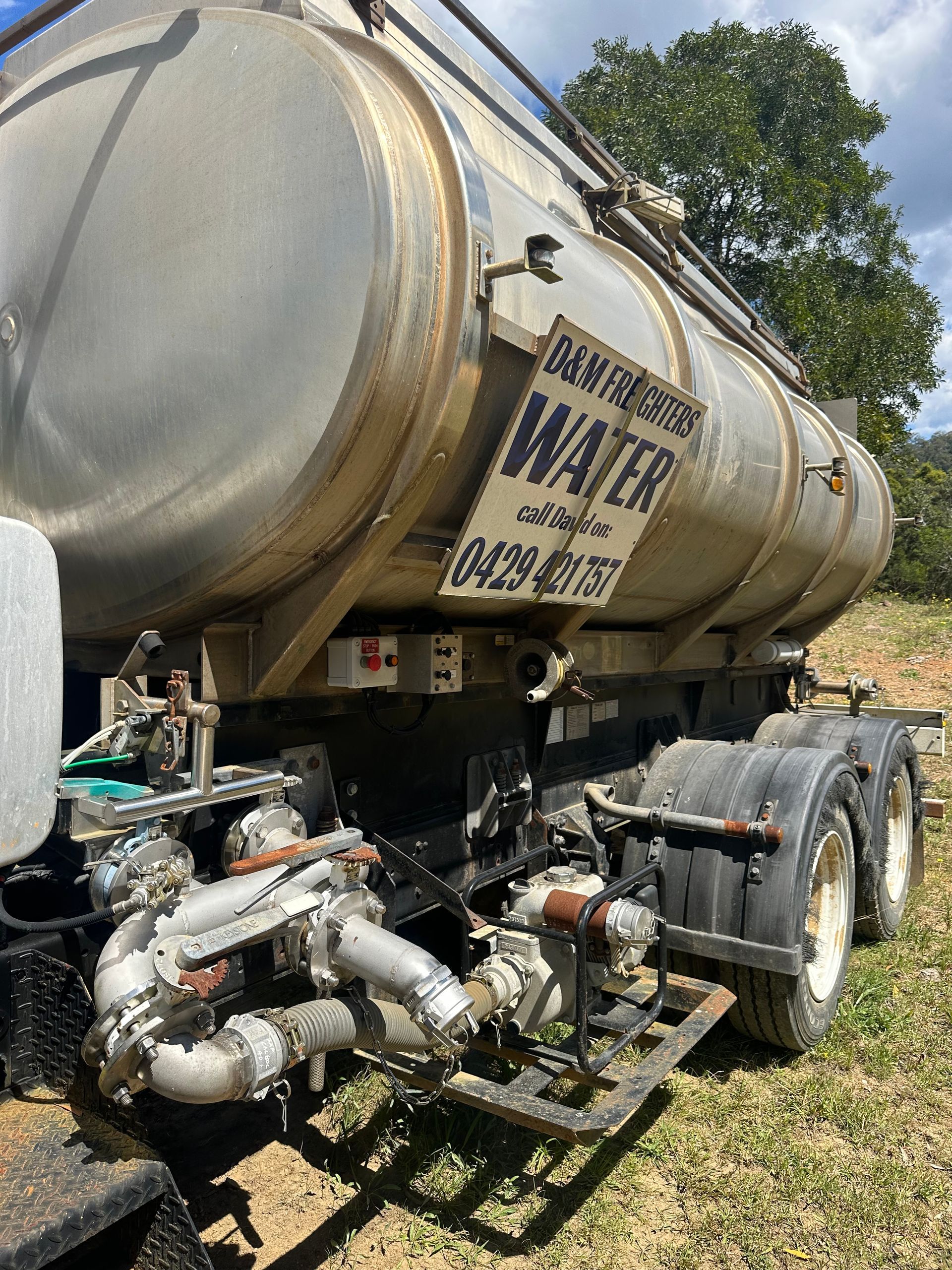 Water tank truck with rusted exterior, white and signage, parked outdoors — D & M Freighters Water In Bulahdelah, NSW