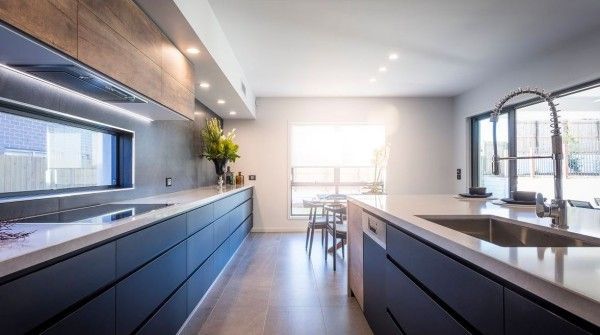 A kitchen with blue cabinets , a sink , and a window.