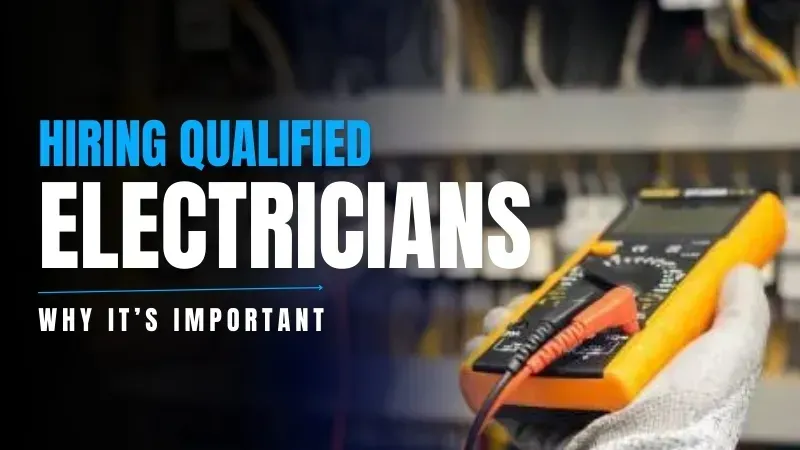 A person is holding a multimeter in their hand in front of a electrical panel.
