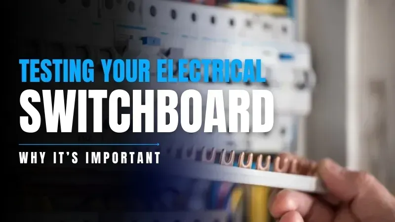 A person is holding a wire in front of an electrical box.