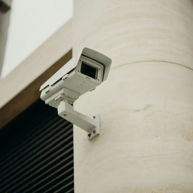 A security camera is mounted on the side of a building.