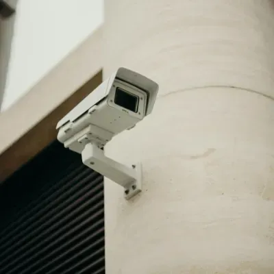 A security camera is mounted on the side of a building.