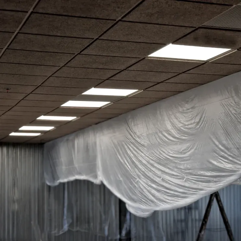 A large sheet of white plastic is hanging from the ceiling of an office