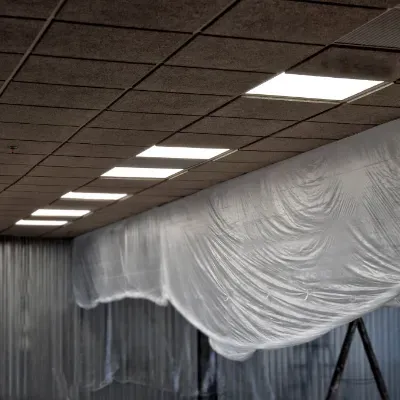 A large sheet of white plastic is hanging from the ceiling of an office