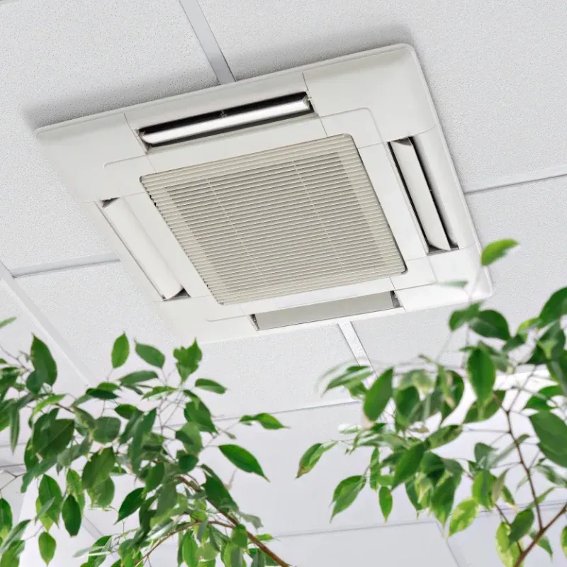 A potted plant is sitting on a desk below a cassette air conditioner