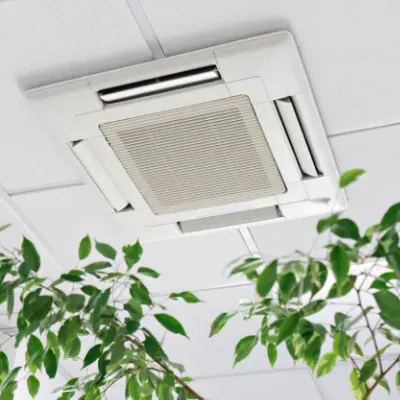 A potted plant is sitting on a desk below a cassette air conditioner
