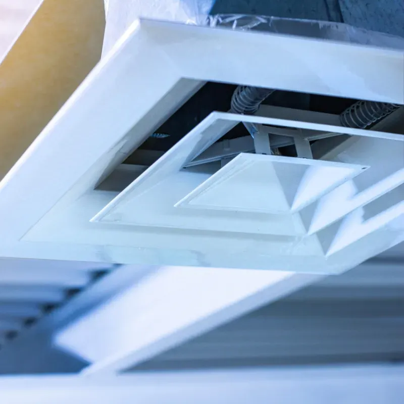 A close up of an air vent on the ceiling of a building.