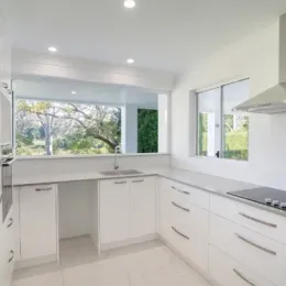 A kitchen with white cabinets and a stove top oven