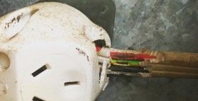 A close up of a broken electrical outlet with a bunch of wires coming out of it.