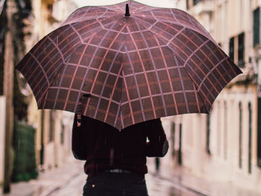 A person is holding an umbrella in the rain.
