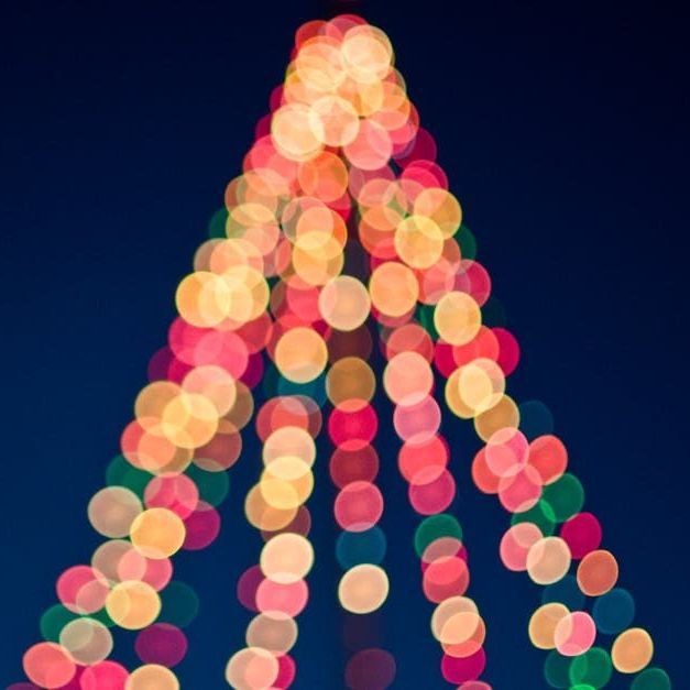 A bunch of colourful Christmas lights against a dark sky