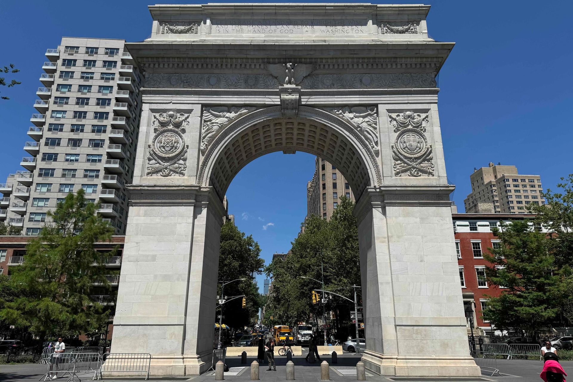 Washington Square Arch rising above the paths and trees of Washington Square Park in NYC.