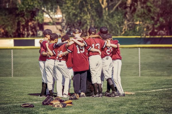 Youth baseball team huddling on the field