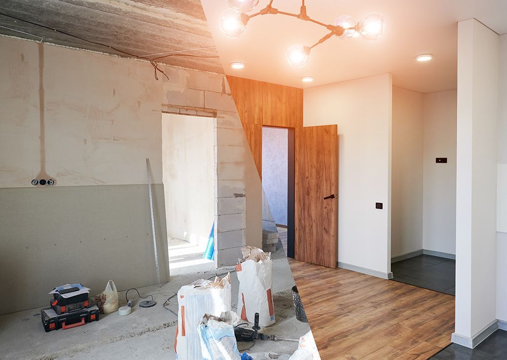 Half-finished room undergoing renovation: exposed wall, doorway, bags of materials, light wood flooring.