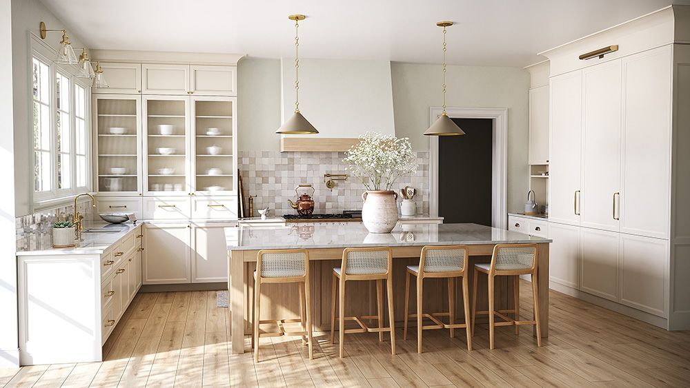 Bright, airy kitchen with wood floors, island with stools, and cream-colored cabinets; sunlight streams through windows.