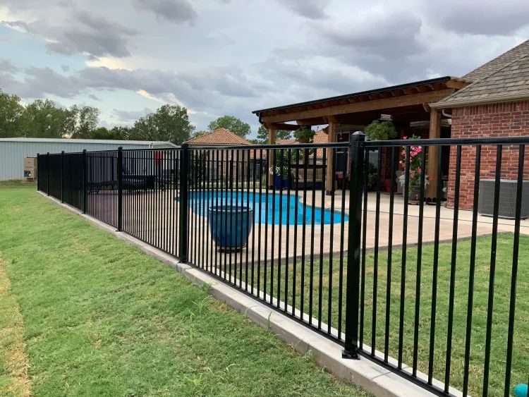 Black aluminum ornamental fence around a residential pool installed by Legacy Fence