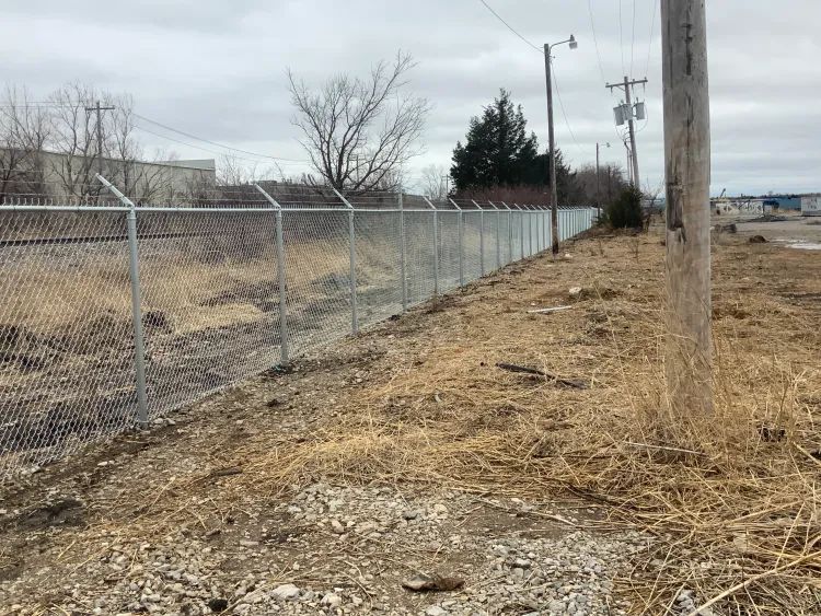 Commercial chain-link fence with barbed wire installed by Legacy Fence