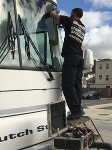 a technician changing a windshield in a large rv