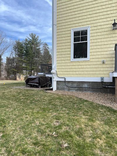 A yellow house with a large lawn in front of it.