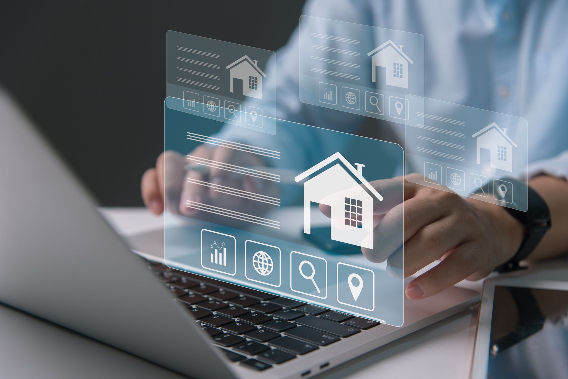 Person using a laptop with a digital interface showing house icons, suggesting real estate or property search.