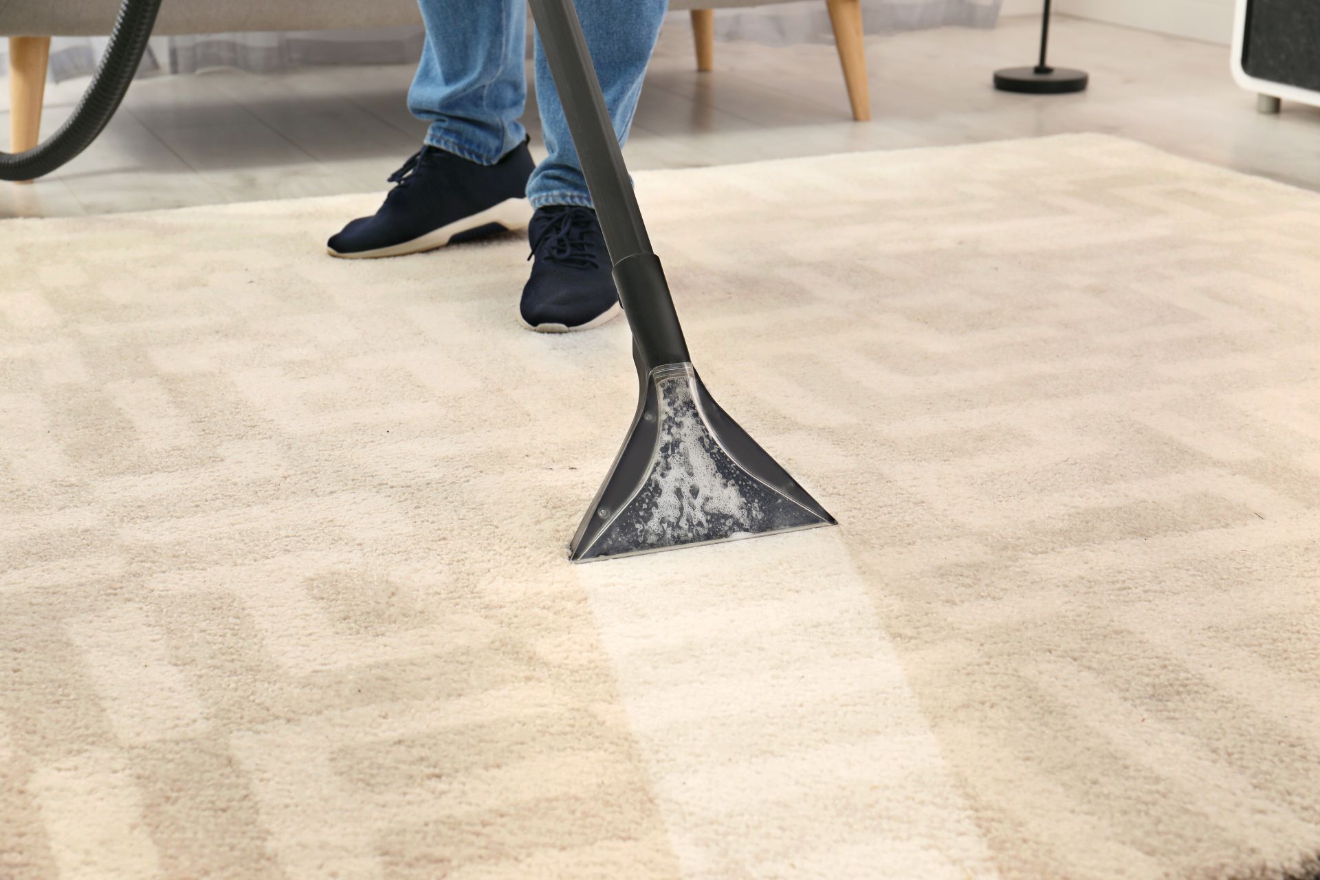 Janitor mopping a shiny floor beside a yellow cleaning cart in a hallway