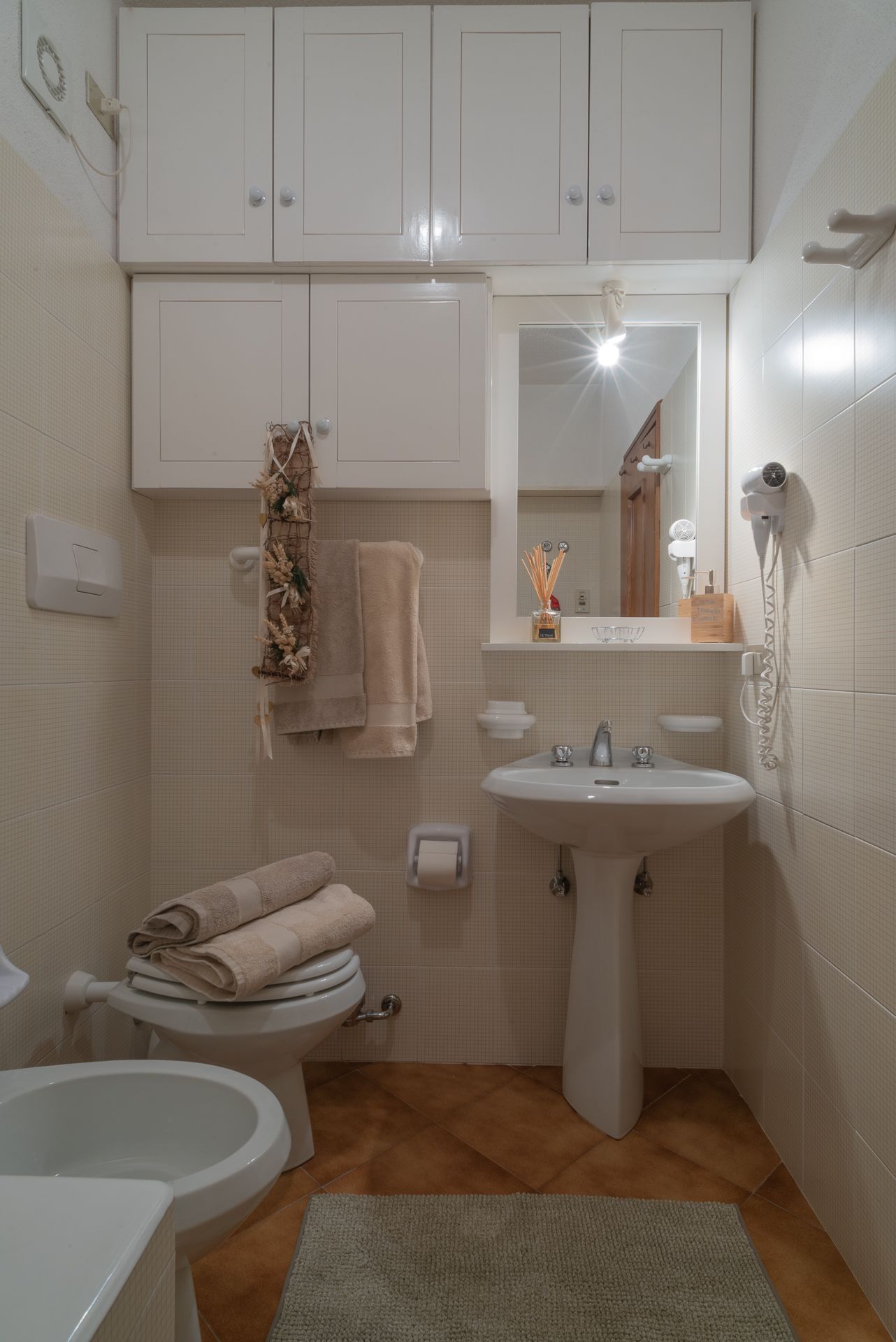 Un bagno con lavandino, wc e specchio