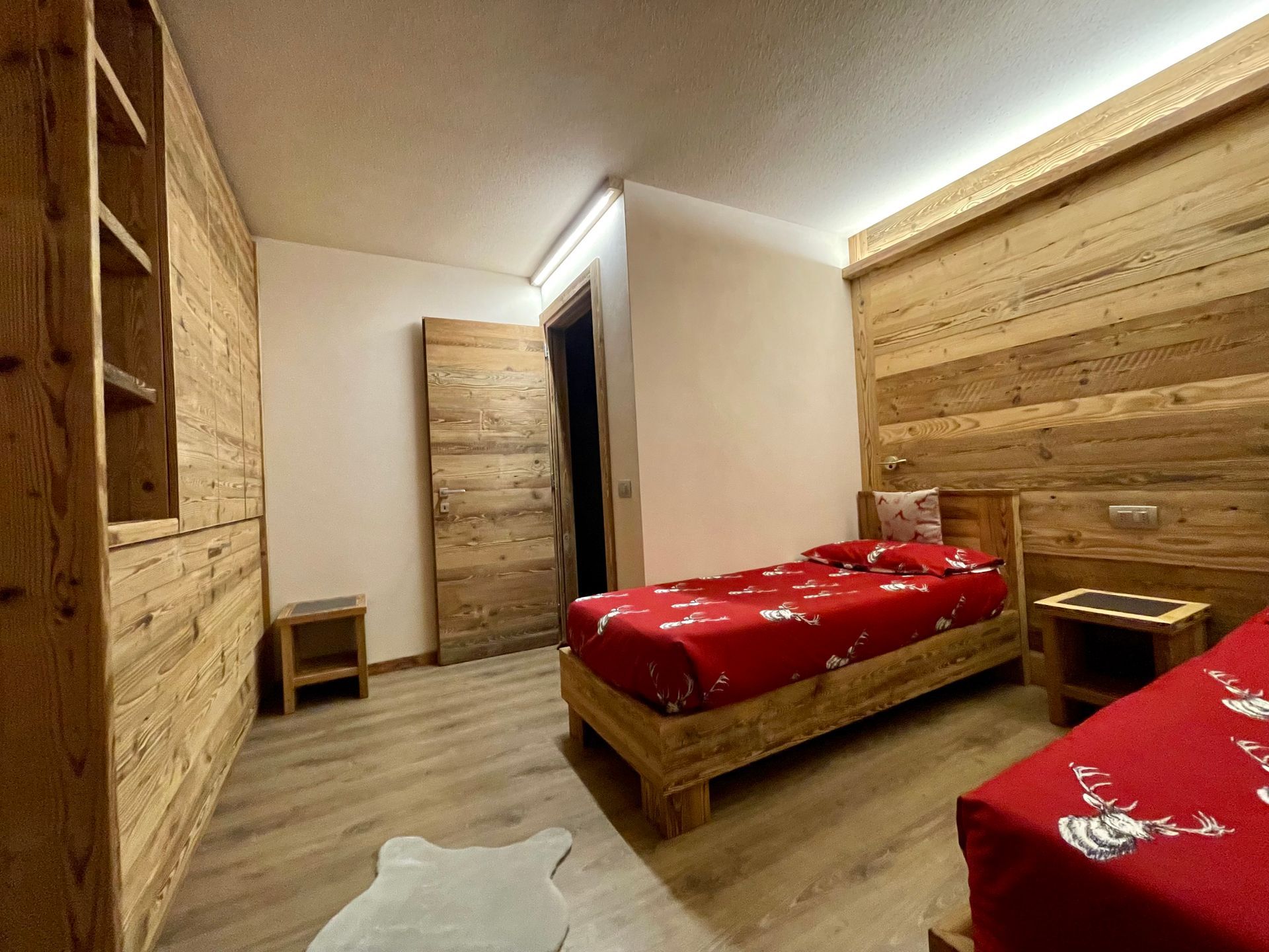 Ci sono due letti nella stanza con pareti in legno.