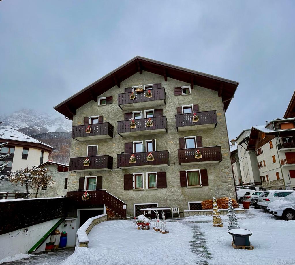 Un grande edificio con molti balconi è coperto di neve