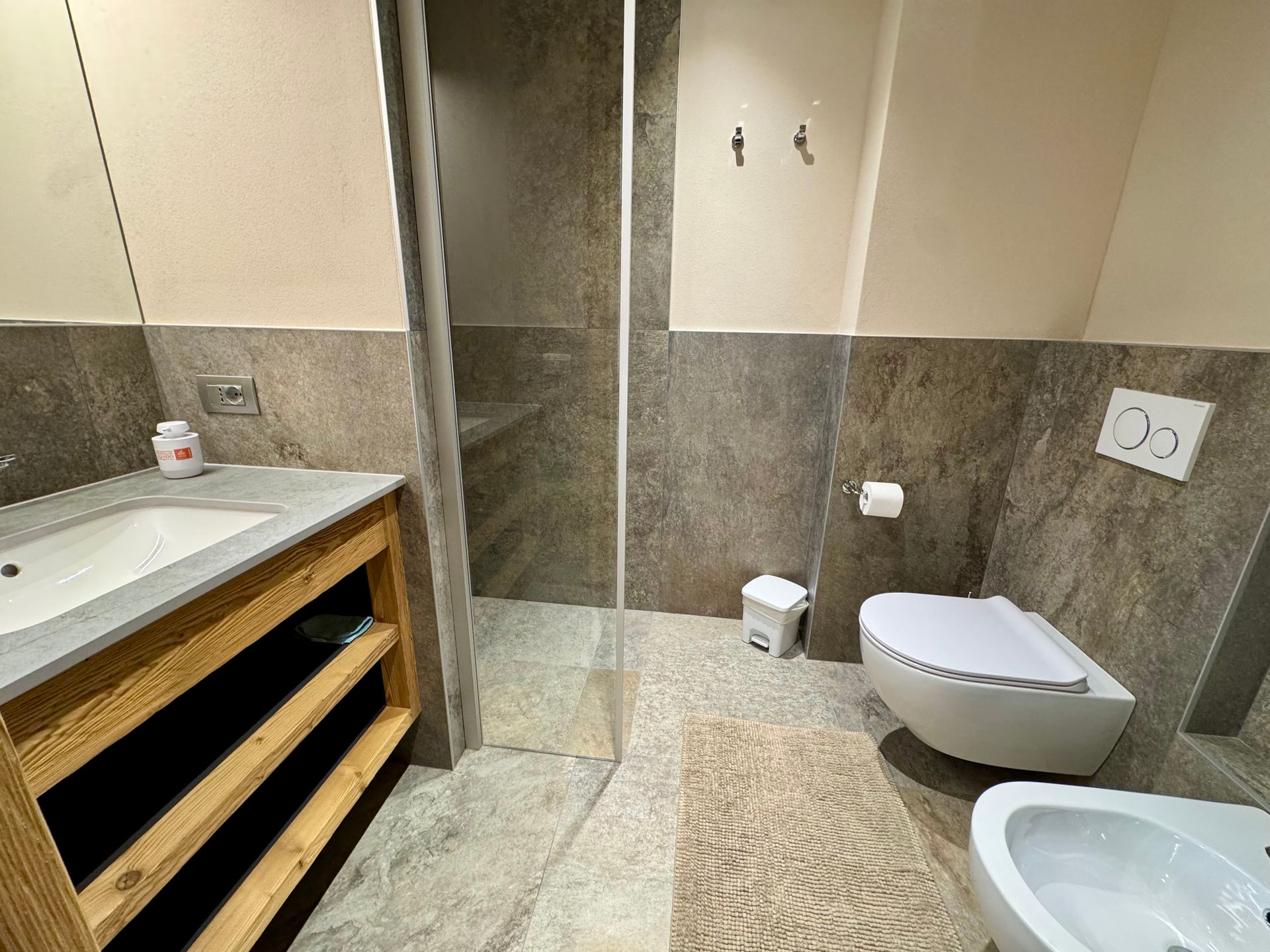 Un bagno con lavandino, wc e specchio