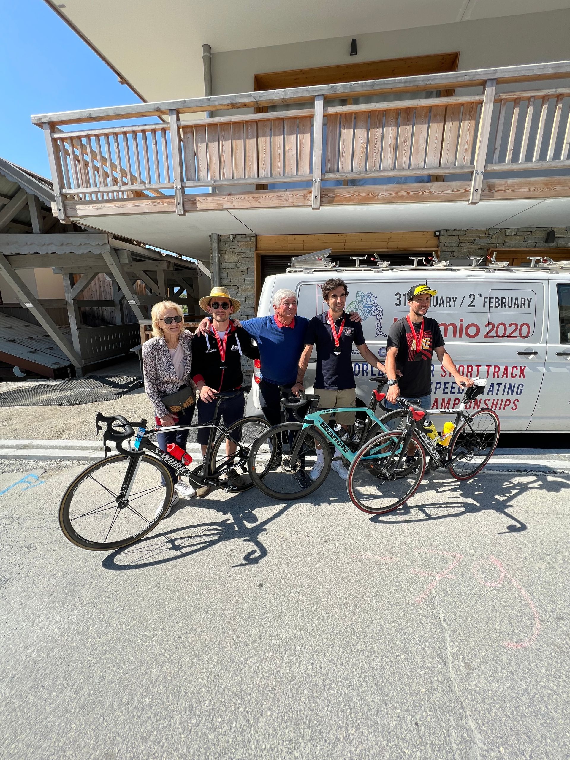 Un gruppo di persone in piedi accanto alle biciclette davanti a un edificio.