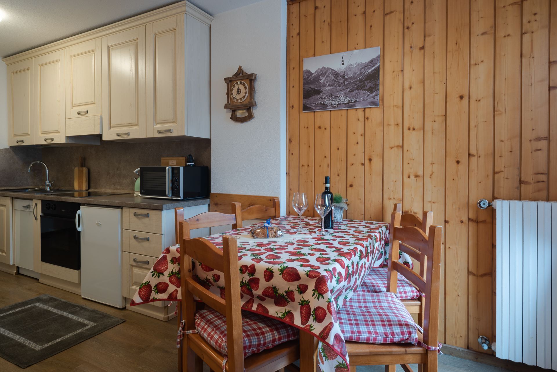 Una cucina con tavolo e sedie e un orologio a parete