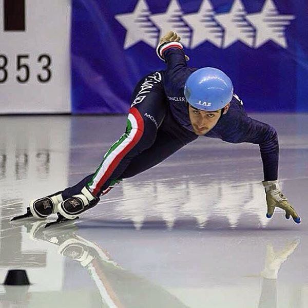 Un uomo sta pattinando sul ghiaccio davanti a un cartello che dice 353