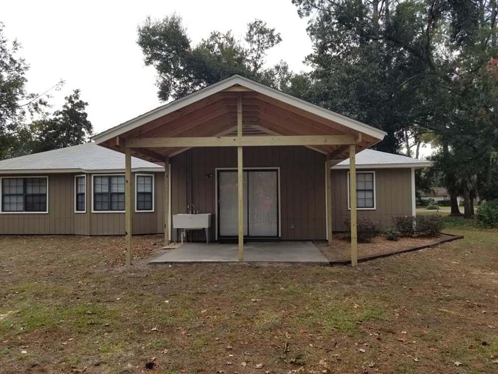 Small rustic house with a covered front porch and wooded yard