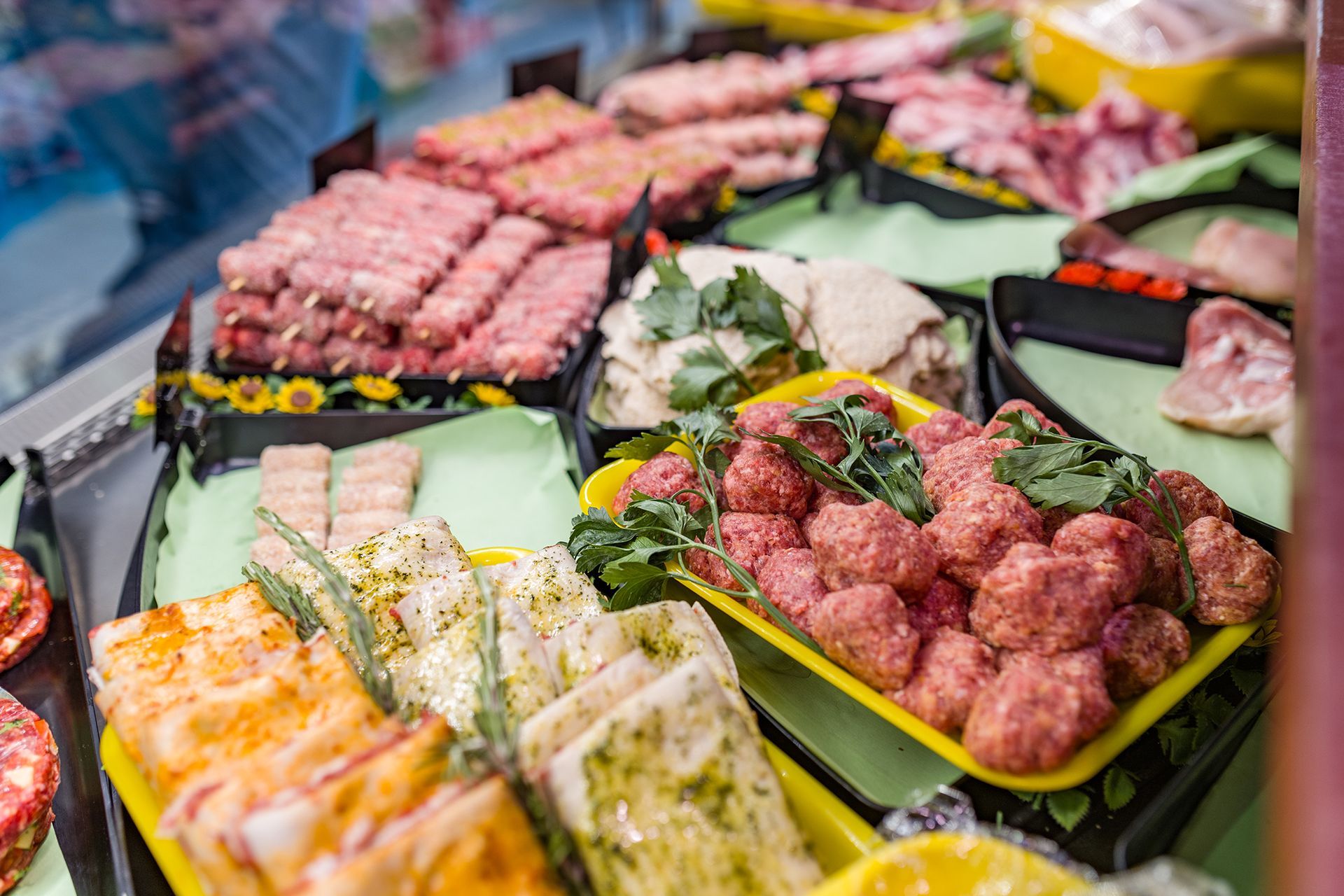 Vassoio con un assortimento di coloratissimi involtini di sushi e piatti di frutti di mare esposti in un mercato.
