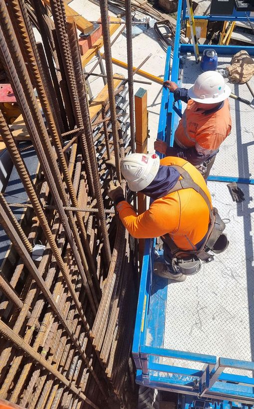 A group of construction workers from Western Steel Fixing working on a building.