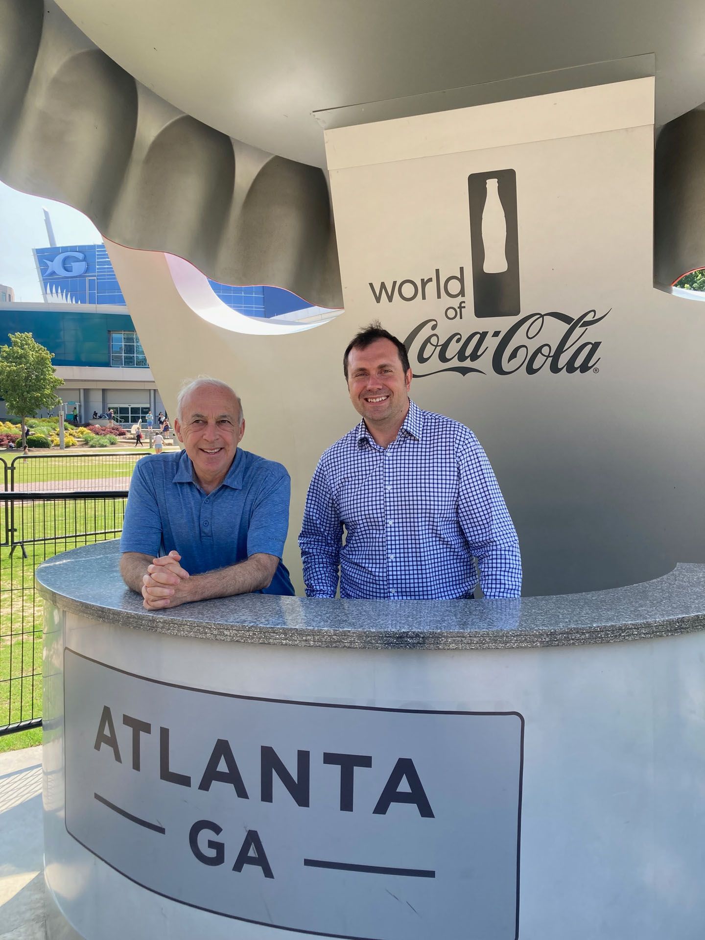 Two men stand behind a counter at the