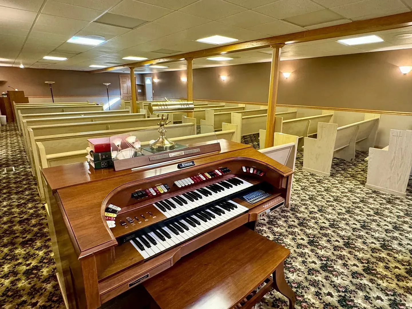 Church sanctuary with pews and a wooden organ in the foreground