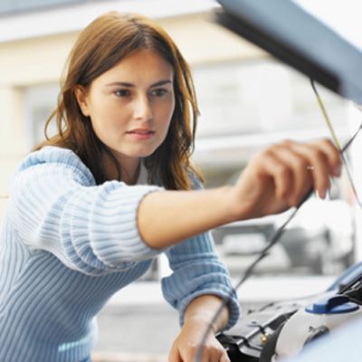 Woman looking at vehicle engine