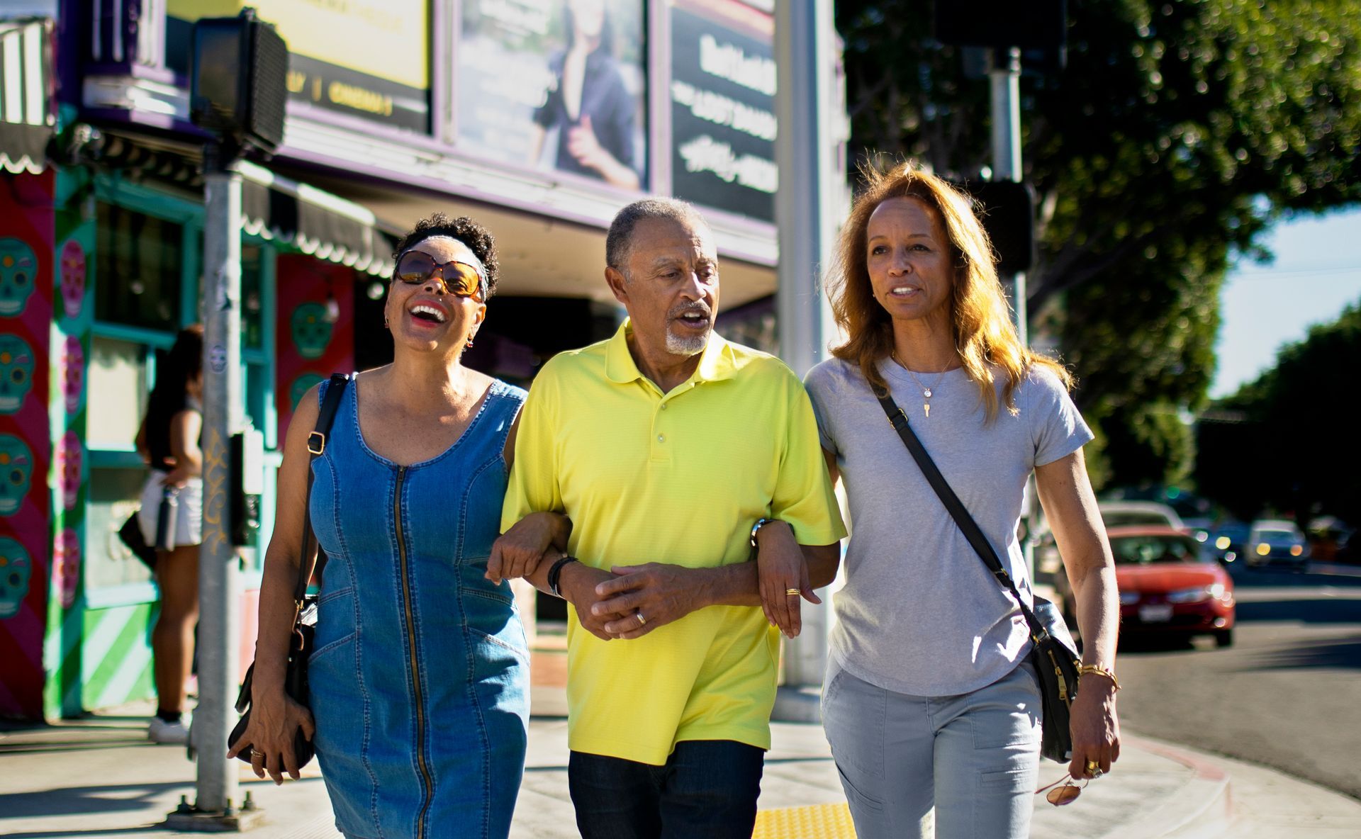 A group of people are walking down a sidewalk.