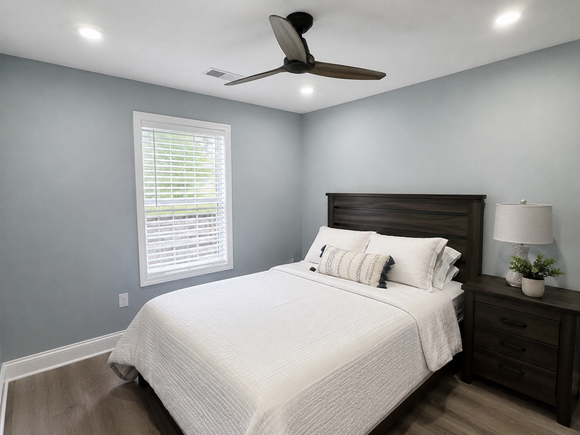 Small bathroom vanity with white sink, mirror, black fixtures, and dark gray walls.